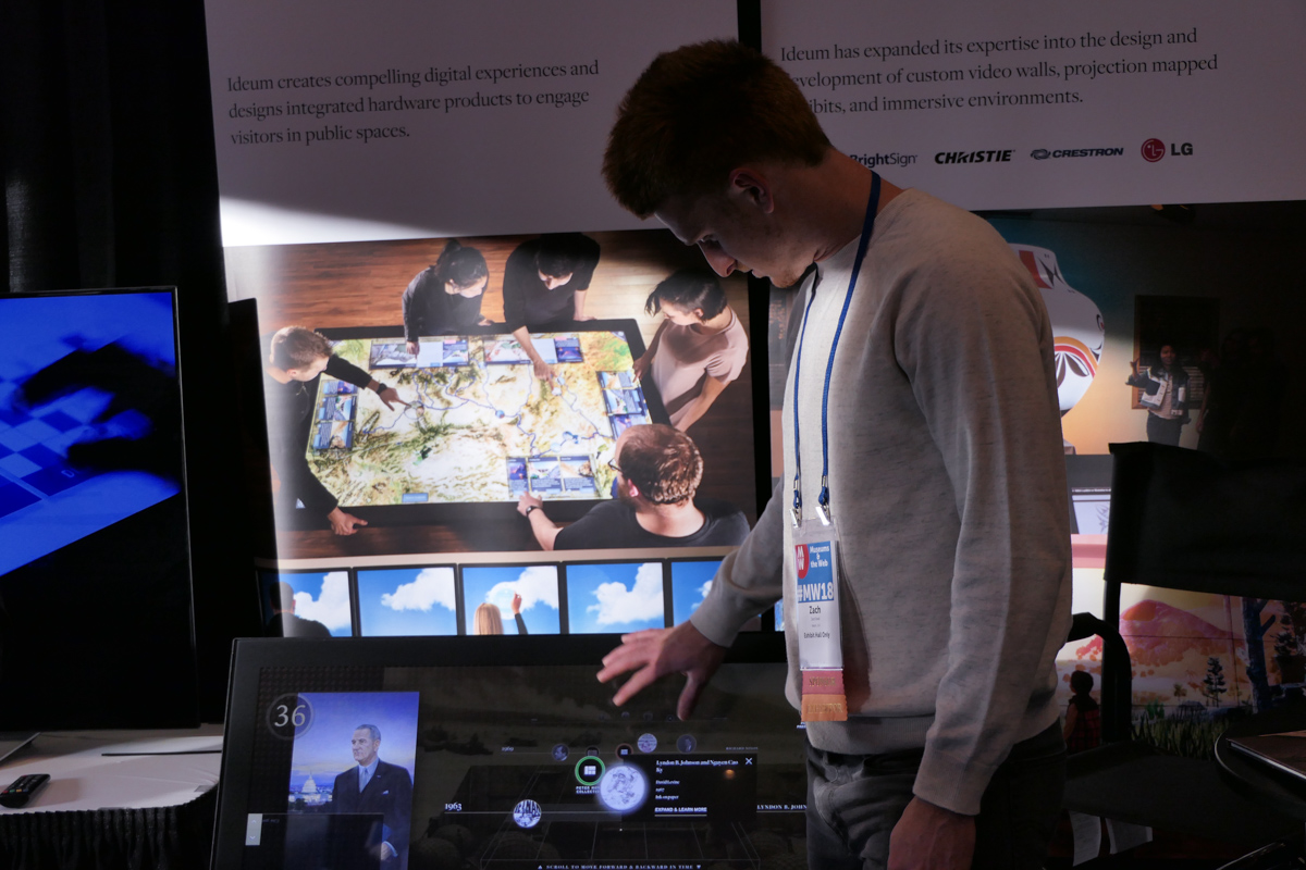 A man shows off an interactive touch screen. 